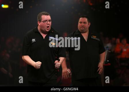 Stephen Bunting (à gauche) célèbre la victoire d'une jambe cruciale alors qu'Alan Norris se réjouit de son refus lors de la finale des championnats du monde de BDO au Lakeside Complex, Surrey. Banque D'Images