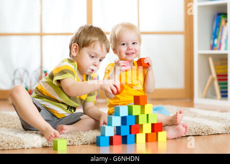 D'âge préscolaire des enfants jouant avec des blocs de jouets colorés. Enfant jouant avec des jouets en bois à la maternelle ou garderie. Dans les jardins d'enfant. Banque D'Images