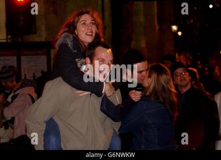 Les fêtards de la place du Parlement regardent les feux d'artifice exploser au-dessus du London Eye pour marquer l'arrivée au Royaume-Uni de 2004. Banque D'Images