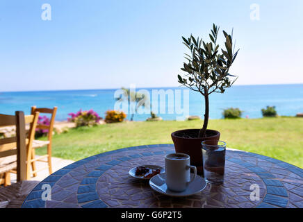 Tasse de café sur une table avec olivier, avec la vue sur la mer et le ciel à Protaras, Chypre. Banque D'Images