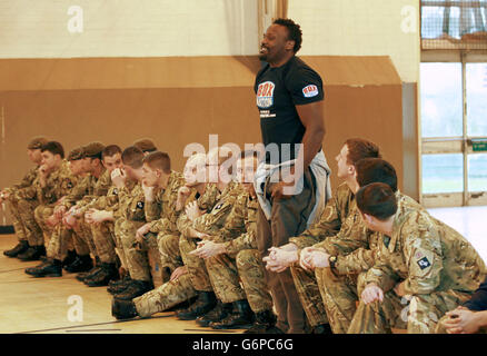 Le boxeur poids lourd Dereck Chisora avec des membres du 2e régiment du bataillon Princess of Wales pendant l'entraînement à la caserne de l'Artillerie royale de Londres. Banque D'Images