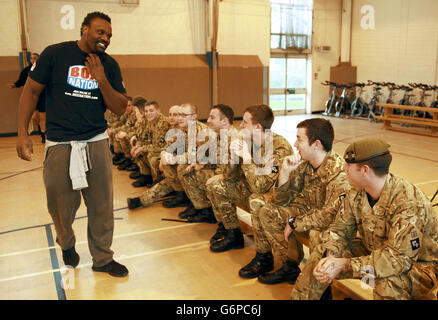 Le boxeur poids lourd Dereck Chisora avec des membres du 2e régiment du bataillon Princess of Wales pendant l'entraînement à la caserne de l'Artillerie royale de Londres. Banque D'Images