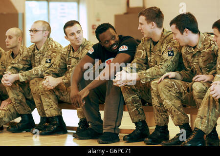 Le boxeur poids lourd Dereck Chisora avec des membres du 2e régiment du bataillon Princess of Wales pendant l'entraînement à la caserne de l'Artillerie royale de Londres. Banque D'Images