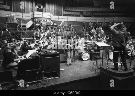 Le chef d'orchestre Malcolm Arnold dirige la répétition du 'Concerto pour groupe et orchestre' de Deep Purple, composé par l'organiste du groupe, Jon Lord. La pièce sera jouée par le groupe pour l'instant, avec l'Orchestre philharmonique royal sous le relais de M. Arnold au Royal Albert Hall en aide à la Task Force. Banque D'Images