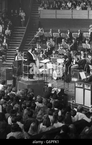 Le chef d'orchestre Malcolm Arnold dirige la répétition du 'Concerto pour groupe et orchestre' de Deep Purple, composé par l'organiste du groupe, Jon Lord. La pièce sera jouée par le groupe pour l'instant, avec l'Orchestre philharmonique royal sous le relais de M. Arnold au Royal Albert Hall en aide à la Task Force. Banque D'Images