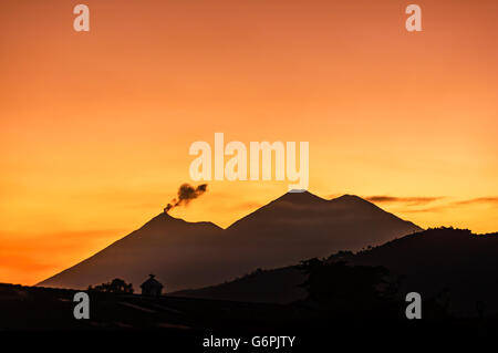 Coucher de soleil sur le tabagisme actif volcan Fuego & double-volcan acatenango striée près de Antigua, Guatemala, Amérique centrale Banque D'Images