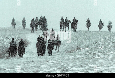 Pris dans le blizzard, les cavaliers et les chevaux se rendent des galops sur la lande haute à Middleham, dans le North Yorkshire, alors que la neige continue de tomber sur les pennines. Les prévisionnistes ont prédit qu'il y aurait d'autres chutes, se déplaçant vers le sud pendant la journée. Banque D'Images