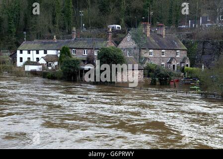 Des maisons le long de la rivière Severn à Ironbridge, près de Telford, dans le Shropshire, avec des jardins déjà inondés, espèrent que des barrières temporaires de défense contre les inondations préviennent les inondations dans leurs maisons.Des milliers de propriétaires pourraient réclamer des inondations et des dommages de subsidence à leurs compagnies d'assurance de biens ont réclamé. Banque D'Images