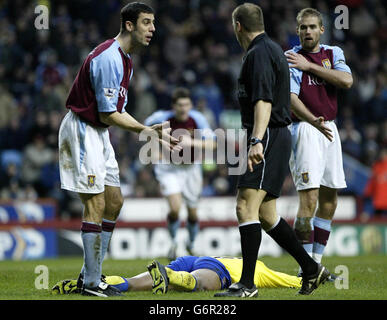 Mark Delaney (à gauche) d'Aston Villa et Olof Mellberg plaident avec l'arbitre Mark Halsey après le châtiment de Kanu d'Arsenal (couché) qui a conduit Thierry Henry à marquer le deuxième but lors du match de First ership de FA Barclaycard à Villa Park, Birmingham. Note finale Aston Villa 0-2 Arsenal. Banque D'Images