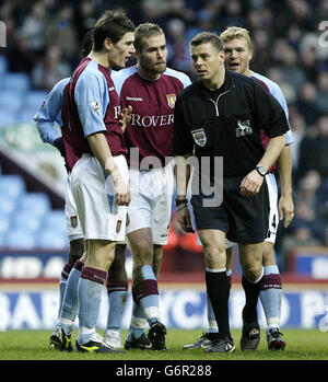 L'arbitre Mark Halsey ignore les appels de Gareth Barry (à gauche) d'Aston Villa, Olof Mellberg et Marcus Allback (à droite) après la pénalité infligée à Kanu (couché) d'Arsenal qui a conduit Thierry Henry à marquer le deuxième but lors du match de Premiership FA Barclaycard à Villa Park, Birmingham. Note finale Aston Villa 0-2 Arsenal. Banque D'Images