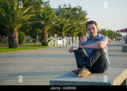 Happy handsome young man eating ice cream- à l'extérieur Banque D'Images
