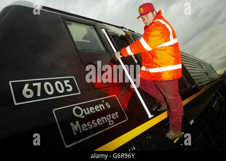 Le technicien en peinture Byrn Davis vérifie la finition de la locomotive de classe 67 « Queen's Messenger » qui tirera le Royal train à l'avenir, et qui a été dévoilée, à l'intérieur de l'EWS (English, Welsh & Scottish Railway) à Toton, près de Nottingham. La locomotive de 90 tonnes remplacera deux moteurs diesel, appelés Prince William et Prince Harry, qui ont tiré le train depuis 1995. Le premier train royal a couru le 13 juin 1842, transportant la reine Victoria de Slough à Paddington sur un trajet de 25 minutes. Banque D'Images