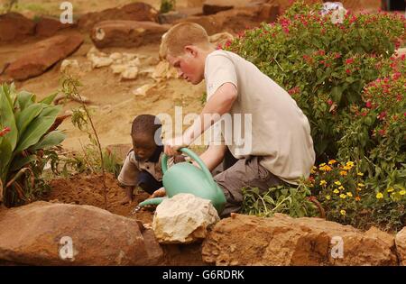 Le prince Harry, le plus jeune fils du prince Charles de Grande-Bretagne, avec le jeune orphelin Mutsu Potsane, 4 ans, après avoir planté un arbre de pêche ensemble à la maison des enfants de Mants'ASE pour les orphelins près de Mohale's Hoek, à environ 60 miles au sud de Maseru au Lesotho. Banque D'Images