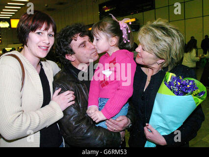 Le demandeur d'asile Bedri Haziri (deuxième gauche) avec sa femme Susan (R) alors qu'ils sont réunis avec leur petite-fille Molly 5 ans et leur fille Kate (extrême gauche) lorsqu'ils se sont rencontrés à l'aéroport d'Heathrow hier soir. Bedri, bien connu et populaire à Teignmouth où il cherchait l'asile après avoir fui son pays natal du Kosovo à cause de la violence, est tombé amoureux d'une femme locale Susan Giesler, et ils se sont mariés en septembre 2000. Avec la menace d'expulsion qui menace le couple, Bedri a été déporté en Albanie en décembre dernier, mais a depuis reçu un visa de conjoint pour être réuni avec sa famille au Royaume-Uni. Banque D'Images