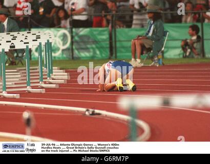 29-JUL-96, Jeux Olympiques d'Atlanta, femmes de 400m haies Heats, la Grande-Bretagne Sally Gunnell croches sur la piste blessés Banque D'Images