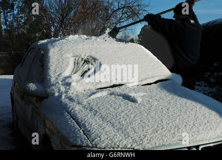 Un automobiliste balaie la neige du toit de sa voiture près de York, alors que les prévisions météorologiques prévoyaient que le grand refroidissement se poursuivrait.Les automobilistes étaient avertis de ne conduire que si nécessaire, car de fortes averses de neige se dirigeaient vers le sud, touchant le pays occidental, l'est des Anglia et le sud de l'Angleterre. Banque D'Images