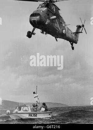 Simon le bon, la star pop de DURAN Duran, est aidé par un winchman de la marine alors qu'il est transporté dans un hélicoptère de la Royal Navy au large de Falmouth, le long de la côte sud de Cornwall, pour la deuxième fois en deux jours. Le bon et trois de ses membres d'équipage avaient navigué dans un bateau à moteur depuis le port de Falmouth pour inspecter les dommages à son yacht maxi de 77 pieds, Drum, qui a chaviré dimanche. Sur le chemin du retour au port, le bon s'est rendu compte qu'il serait en retard pour une réunion et a réussi à monter à bord d'un hélicoptère Wessex. Banque D'Images