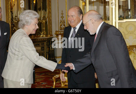 La reine Elizabeth II de Grande-Bretagne rencontre le président de l'Association de football Geoffrey Thompson (à droite) et le président de la FIFA, Sepp Blatter, lors d'une réception au Palais de Buckingham à Londres pour marquer le centenaire de l'organe dirigeant du jeu dans le monde entier. Banque D'Images