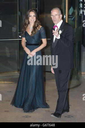 La duchesse de Cambridge, portant une robe de la designer britannique Jenny Packham et un collier de prêt de la reine Elizabeth II qui a été donné à la reine comme cadeau pour son mariage en 1947, marche avec Sandy Nairne, directeur de la National Portrait Gallery, Alors qu'elle arrive pour le Gala du portrait 2014 au National Portrait Gallery dans le centre de Londres. Banque D'Images