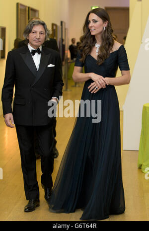 La duchesse de Cambridge, portant une robe de la designer britannique Jenny Packham et un collier de prêt de la reine Elizabeth II qui a été donné à la reine comme cadeau pour son mariage en 1947,Marche avec un invité au Gala du portrait 2014 au National Portrait Gallery dans le centre de Londres. Banque D'Images