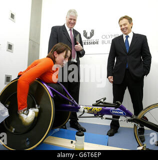 Le vice-chancelier de l'Université, le professeur Graham Henderson, est aux côtés du Premier ministre britannique Tony Blair (à droite), alors qu'il observe l'athlète handicapé Sarah Loughran train, dans la Chambre de l'environnement, lors de sa visite à l'édifice Olympia de l'Université de Teeside à Middlesbrough. Au début, dans un discours d'ouverture dans sa circonscription, M. Blair a défendu avec passion la guerre en Irak et a affirmé que l'attaque des tours jumelles du 11 septembre était venue comme une « vélation » qui l'a convaincu de la nécessité de s'attaquer aux États voyous. Banque D'Images