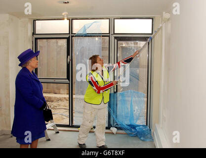 Queen Elizabeth II montres Saskia Harris décorer de nouveaux appartements à Maryland point, Stratford, dans le cadre du programme d'éducation des femmes dans le bâtiment.La Reine, qui a été rejointe par la princesse royale, a visité le site de la construction où ils ont vu des étudiantes, qui apprennent l'art de la menuiserie, de la plomberie, de la peinture et de la décoration, comme une nouvelle façon de gagner leur vie. Banque D'Images