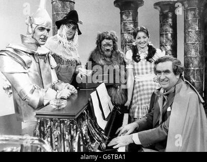 Le chancelier de l'Échiquier Denis Healey se joint à la fête de Noël lors des répétitions de la version nationale de 'The Wizard of Oz', qui sera diffusée sur BBC One.Dans cette scène, au tournant du château de l'expert, les présentateurs nationaux Sue Lawley (Dorothy), John Stapleton (Tin man), Bob Wellings (Straw man) et Richard Stilgoe (Lion) rencontrent M. Healey, qui est vêché et joue « au-dessus de l'arc-en-ciel », avec une boîte rouge perchée sur le piano.Avant que quelqu'un puisse passer Healey demande une contribution au FMI - le Fonds des magiciens internationaux. Banque D'Images