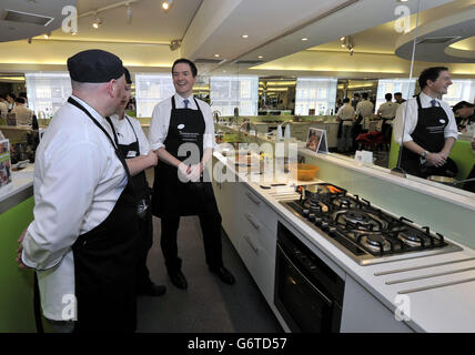 Le chancelier de l'Échiquier George Osborne se joint aux chefs stagiaires d'une école de cuisine lors d'une visite au Dean Clough Mills à Halifax, où il a visité de petites entreprises lors de son voyage dans le West Yorkshire, afin de promouvoir l'introduction de l'allocation d'emploi en avril. Banque D'Images