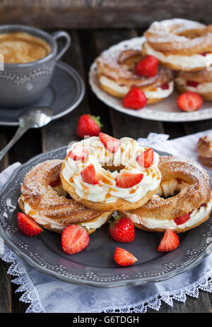 Chou à la crème (pâte à choux) décoré avec des fraises fraîches et sauce au caramel Banque D'Images