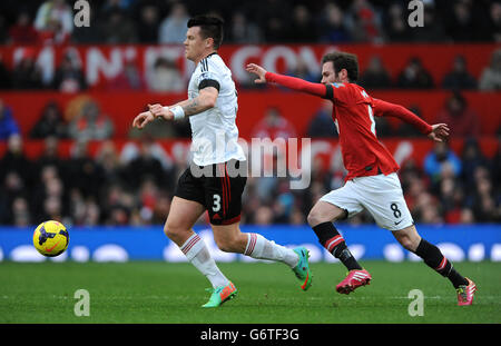 Football - Barclays Premier League - Manchester United / Fulham - Old Trafford.John Arne Riise de Fulham (à gauche) et Juan Mata (à droite) de Manchester United se battent pour le ballon. Banque D'Images