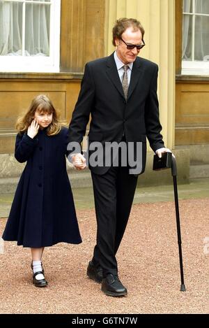 Le chanteur des années soixante Ray Davies, 59 ans, du groupe The Kinks avec sa fille Eva, 7 ans, après avoir reçu une CBE pour des services de musique dans la liste des distinctions honorifiques du nouvel an, lors d'une cérémonie d'investiture qui s'est tenue au Palais de Buckingham, à Londres. Banque D'Images