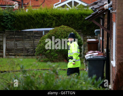 Un policier se tient à l'extérieur d'une maison sur Emily Street à Blackburn, dans le Lancashire, après la mort d'une jeune fille de onze mois lorsqu'elle a été malléée par un chien de compagnie. Banque D'Images