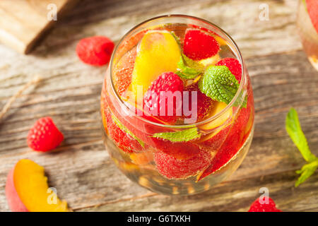 Vin blanc mousseux Sangria faite maison avec des pêches et framboises Banque D'Images