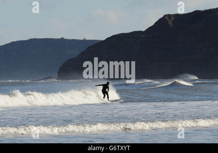 Un surfeur bénéficie du soleil d'hiver à South Bay, Scarborough. Banque D'Images