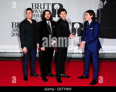Alex Turner (deuxième à droite), Jamie Cook (deuxième à gauche), Nick O'Malley (droite) et Matt Helders (gauche) de Arctic Monkeys arrivant pour les Brit Awards 2014 à l'O2 Arena, Londres. Banque D'Images