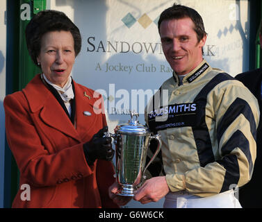 La princesse royale avec le capitaine de jockey Harry Wallace après sa victoire sur Fredo dans la reine Elizabeth la Reine mère Memorial amateur Riders Steeple Chase, pendant la grande journée militaire de la coupe d'or à Sandown Park, Sandown. Banque D'Images