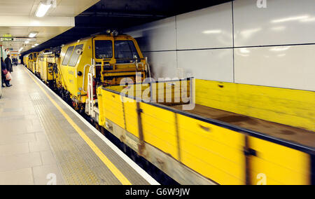 Un train d'ingénierie de transplantation sur le métro de Londres (LU) en direction de l'est Central Line, qui traverse la gare Mile End Station, à l'est de Londres. Banque D'Images