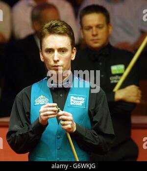 Ken Doherty, de l'Irlande, craque son message lors de son match contre Joe Swail (à droite) le jour d'ouverture du Championnat du monde de l'ambassade au Crucible Theatre, Sheffield, samedi 17 avril 2004. Banque D'Images