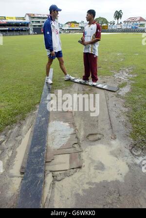 Le capitaine d'Angleterre Michael Vaughan (à gauche) et le capitaine des Indes occidentales Ramnaresh Sarwan discutent de l'état du terrain de l'ovale Bourda à la suite de fortes pluies à Georgetown, Guyana, le samedi 17 avril 2004, avant la première journée internationale. Banque D'Images