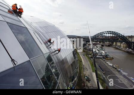 Le dernier panneau de la Sage Gateshead, qui domine le côté revitalisé de la rivière Tyne sur Tyneside, lentement aménagé sur le côté de l'unique bâtiment en verre. Le Sage, qui sera l'un des sites de musique les plus individuels du pays, a coûté 70 millions à construire. Le spectaculaire toit en acier incurvé, qui pèse 750 tonnes, est fabriqué à partir de 3,000 panneaux en acier inoxydable et de 250 panneaux en verre. Banque D'Images