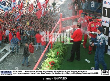 25 août 96, le vainqueur de la course Michael Schumacher, Mika Hakkinen et Jacques Villeneuve vaporisent du champagne au patron de Ferrari Jean Todt au Grand Prix de Belgique Banque D'Images