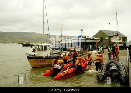 Les sauveteurs amènent leur bateau dans le quai après leur recherche près de Barmouth, au nord du pays de Galles, pour le maître du port et son assistant - les deux membres de l'équipage du canot de sauvetage local - qui ont été vus pour la dernière fois poser un amarrage lundi matin.Leur bateau a plus tard été retrouvé retourné dans l'estuaire.Des bateaux de sauvetage, des patrouilles de recherche des garde-côtes, des équipes de sauvetage en montagne et des hélicoptères de police et de RAF ont participé à la recherche. Banque D'Images