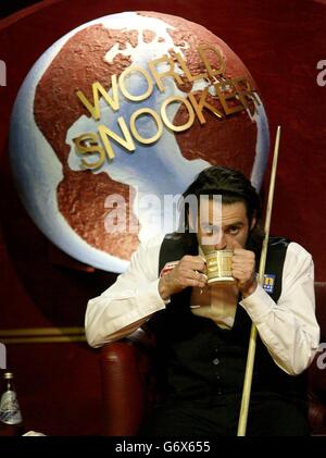 Le Ronnie O'Sullivan, en Angleterre, se fait un verre d'une tasse lors de son match de demi-finale contre Stephen Hendry aux Championnats du monde de snooker de l'ambassade de 2004 au Crucible Theatre, à Sheffield. Banque D'Images