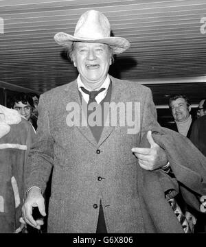 John Wayne.L'acteur de cinéma d'Hollywood John Wayne - Duke à ses amis - arrivant à l'aéroport d'Heathrow des États-Unis Banque D'Images