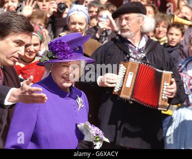 La reine Elizabeth II de Grande-Bretagne lors d'une promenade à la place du Capitole à Toulouse, lors de sa visite officielle en France. Elle a été présentée avec une potée des fleurs violettes et une boîte de gourmandises violettes, y compris le miel violet, ainsi que le thé violet - dit avoir été un favori de la reine Victoria. Banque D'Images