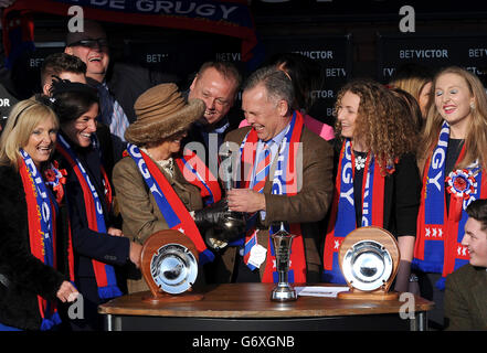 Camilla, Duchesse de Cornouailles (5e à gauche) présente le trophée aux connexions gagnantes de Sire de Grugy après avoir remporté le BetVictor Reine mère Championne Steeple Chase Banque D'Images