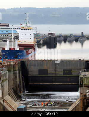 Les ouvriers effectuent l'entretien d'un quai sec à proximité alors que les travaux se poursuivent sur le porte-avions HMS Queen Elizabeth dans un quai à proximité de Rosyth Docks à Fife. Banque D'Images