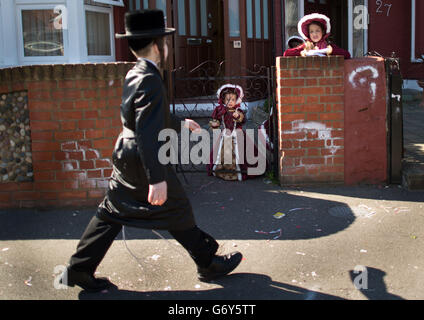 Les enfants juifs orthodoxes célèbrent le festival de Purim dans les rues de Stamford Hill, dans le nord de Londres. Le jour férié qui commémore la délivrance du peuple juif dans l'ancien Empire Perse de la destruction à la suite d'un complot de Haman, Une histoire enregistrée dans le Livre biblique d'Esther est marquée par des parties dans lesquelles les enfants portent des costumes habillés de fantaisie et prennent des cadeaux à des amis voisins et à la famille. Banque D'Images