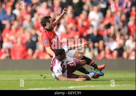 Leandro Bacuna (devant) de la Villa Aston fait tomber Juan Mata de Manchester United pour concéder une pénalité Banque D'Images