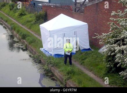 Un policier se tient près d'une tente érigée où un policier des West Midlands dans ses années 40 a été poignardé, dans la région de Nechells à Birmingham. Banque D'Images